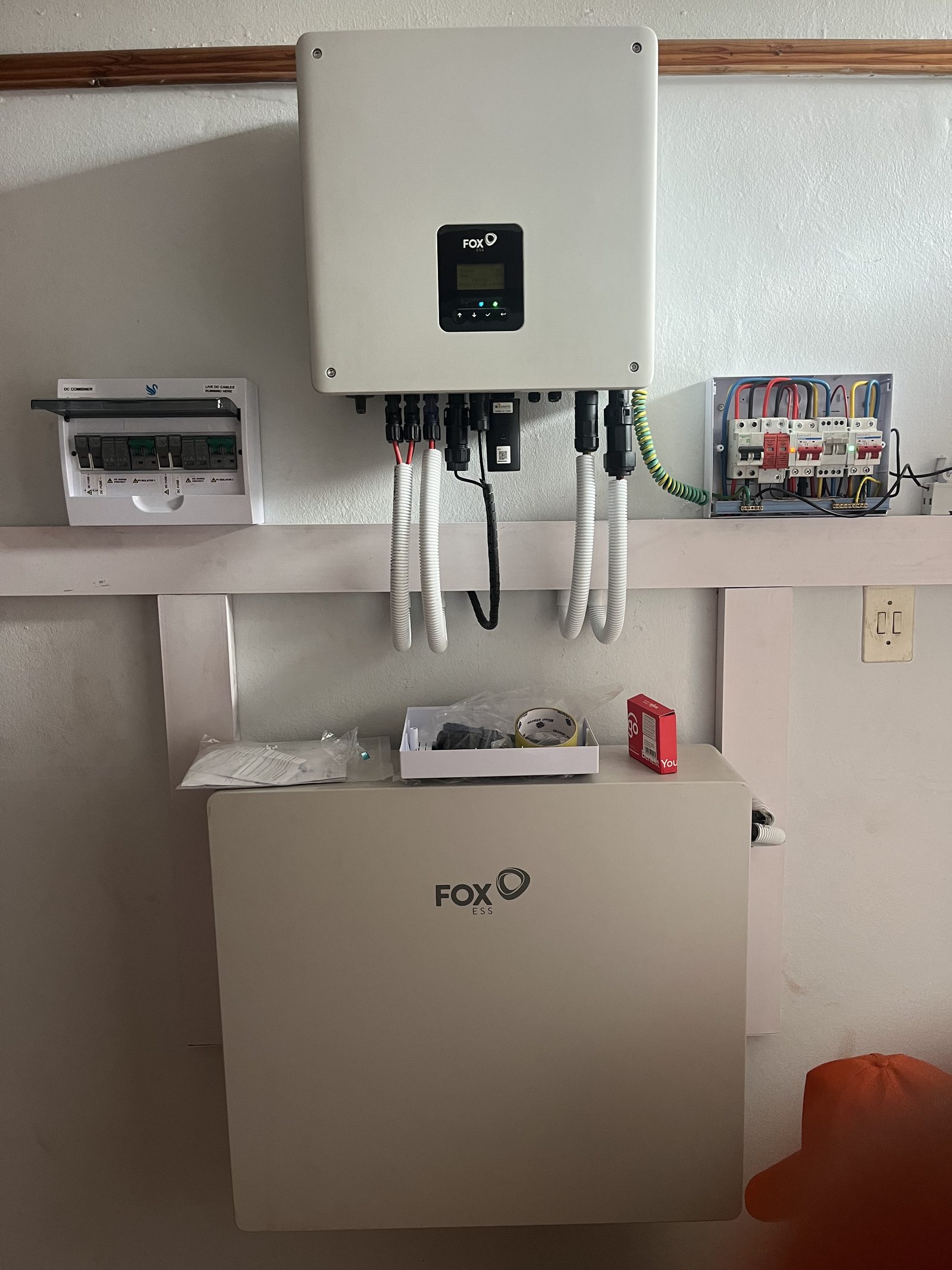 Finished installation with Fox ESS hybrid inverter, DC combiner, AC board and Fox ESS battery neatly mounted on the wall