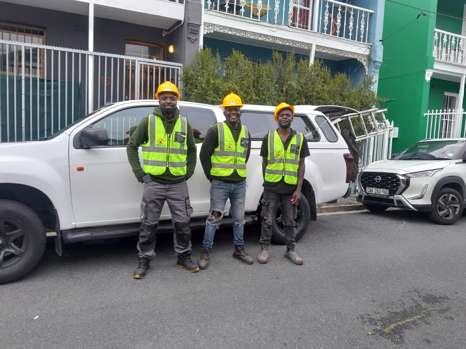 The Sundial Solar installation team standing in front of their bakkie in hi-vis vests and hard hats